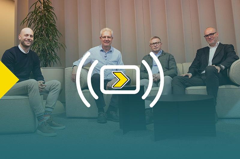 Four men seated on a sofa facing the camera