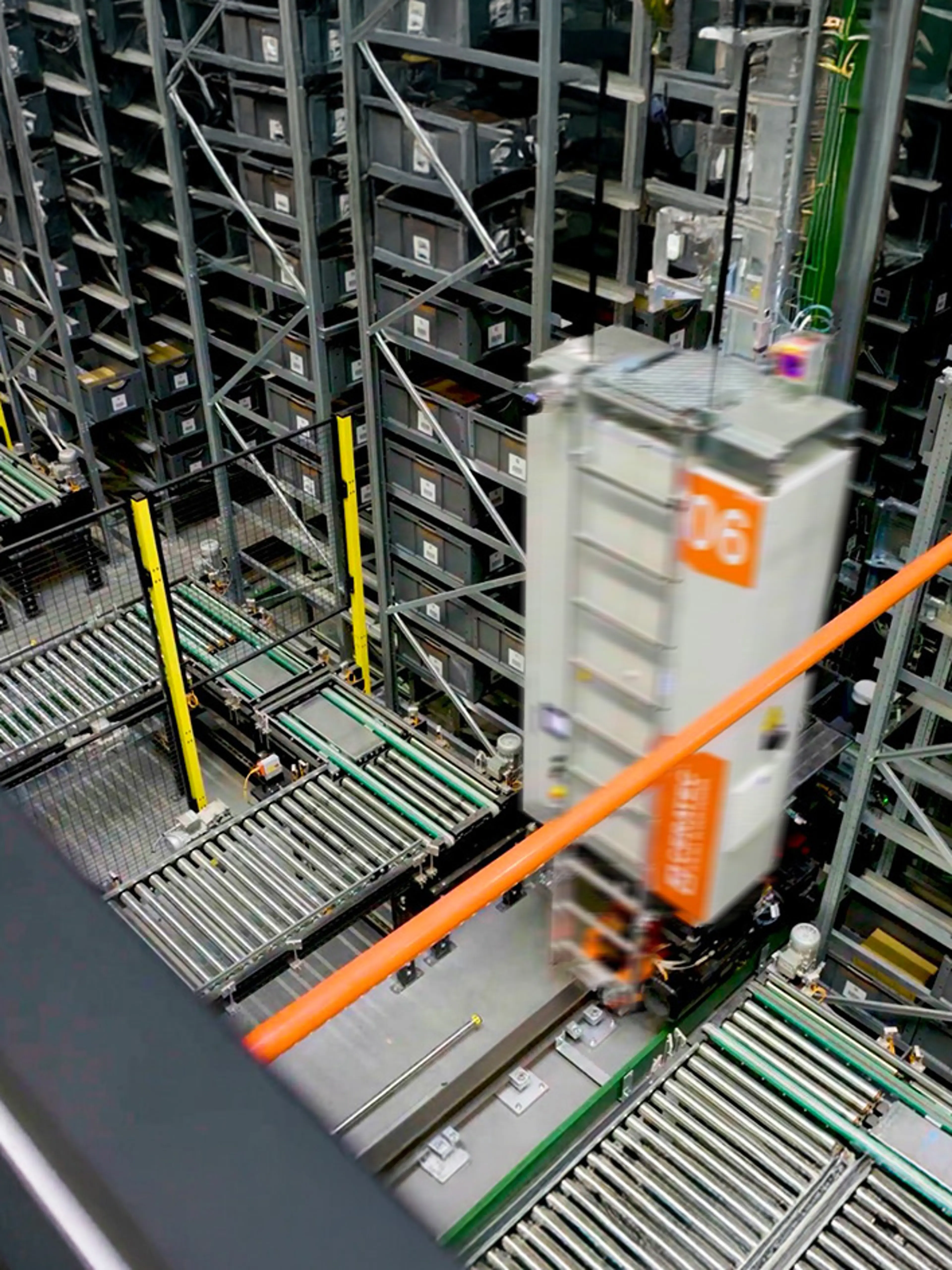 Automated warehouse with conveyor belts and a fast-moving storage robot between tall racks of bins